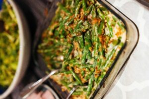 A green bean casserole topped with fried onions in a glass baking dish.